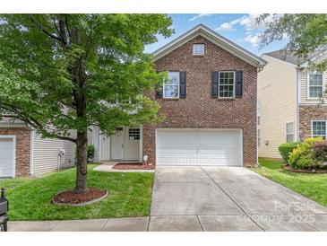 Charming brick home featuring an attached garage, manicured lawn, and mature shade tree in the front yard at 9630 Turning Wheel Dr, Charlotte, NC 28214