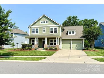 Charming two-story home with a welcoming front porch and well-maintained green lawn at 11324 Fullerton Place Nw Dr, Huntersville, NC 28078