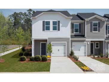 Charming townhome showcasing modern architecture, a well-manicured lawn, and an attached single-car garage at 1720 Old Rivers Rd, Concord, NC 28027