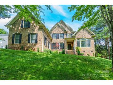 Traditional brick home with black shutters and a well-manicured lawn at 1868 Chestnut Hill Dr, Tega Cay, SC 29708