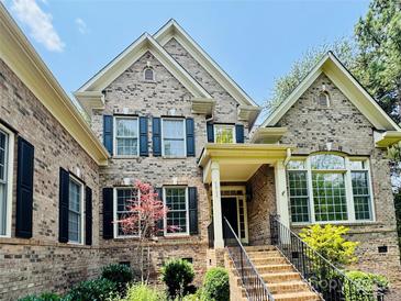 Elegant brick home featuring a well-manicured lawn, classic black shutters, and inviting front entryway at 1868 Chestnut Hill Dr, Tega Cay, SC 29708