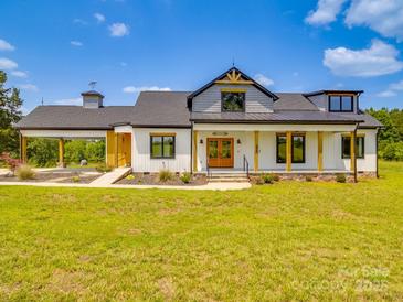 Stunning two-story modern farmhouse features a large front yard and a welcoming covered entry at 2410 Charlotte Hwy, York, SC 29745
