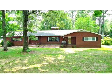 Charming single-story brick home with a well-manicured lawn and mature trees, inviting curb appeal at 3158 Salisbury Hwy, Statesville, NC 28677
