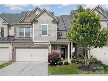 Charming townhome exterior featuring a well-manicured lawn and attached two-car garage at 4012 Woodsmill Rd, Fort Mill, SC 29707