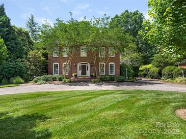 Beautiful brick home featuring manicured landscaping, mature trees, and a circular driveway at 4026 Sharon View Rd, Charlotte, NC 28226
