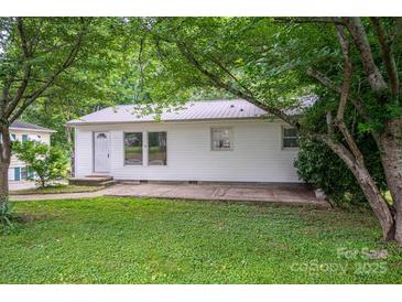Charming single-story home with white siding, metal roof, and mature trees surrounding the property at 535 Norman Fair Ave, Lincolnton, NC 28092