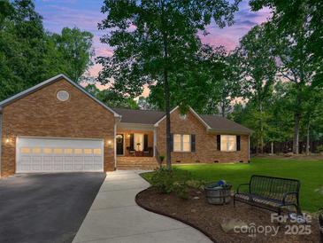 Charming brick home with a well-manicured lawn, inviting front porch, and an attached two-car garage, perfect for suburban living at 7300 Bailywick Dr, Waxhaw, NC 28173