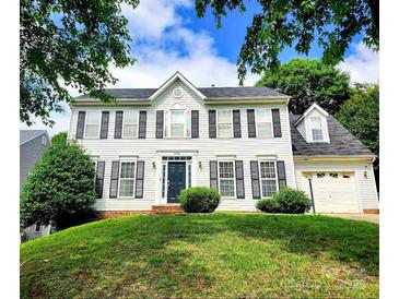 Traditional two-story home with white siding, black shutters, manicured lawn, and mature trees at 9146 Austin Ridge Ln, Charlotte, NC 28214
