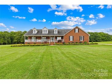 Charming brick home with a pristine front yard, inviting porch, and colorful flower beds at 106 Laren Rd, Shelby, NC 28152
