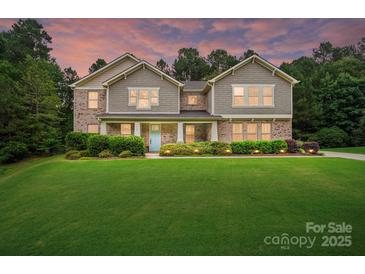 Inviting two-story home featuring a large, manicured front lawn and a charming, light blue front door at 110 St Sophia Ct, Mooresville, NC 28117