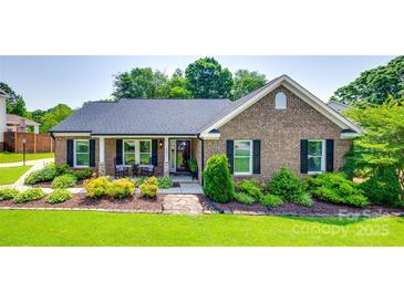 Charming one-story brick home with well-manicured lawn and inviting front porch at 12311 Bentcreek Ln, Matthews, NC 28105