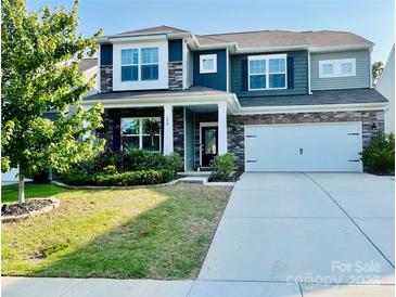 Charming two-story home with stone accents, a well-manicured lawn and an attached two-car garage at 150 Haddonsfield Dr, Mooresville, NC 28115