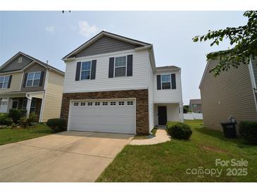 Charming two-story home featuring a stone facade, white siding, and a two-car garage at 3014 Green Apple Dr, Dallas, NC 28034
