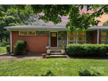 Charming brick and stone home with a well-manicured lawn, inviting entrance, and beautiful landscaping at 4232 Randolph Rd, Charlotte, NC 28211
