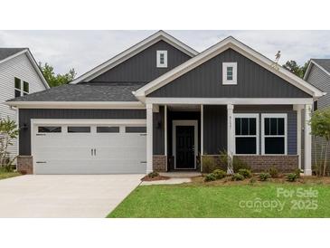 Charming home featuring a two-car garage, neat landscaping, and a welcoming covered front porch at 438 Bent Burr Crk, York, SC 29745