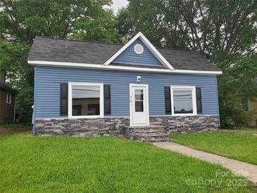 Charming blue home with stone accents, black shutters, and a well-maintained lawn at 518 N Fulton St, Salisbury, NC 28144