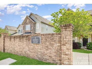 Charming townhome with a brick sign and landscaped front, nestled within the Ardrey Court community at 10105 Community House Rd, Charlotte, NC 28277