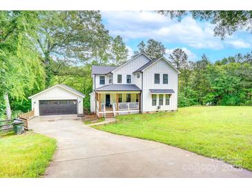 Charming two-story home with a welcoming front porch, detached garage, and a spacious, well-manicured lawn at 1062 Willow Ridge Ln, Fort Mill, SC 29707