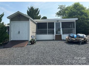Charming home exterior featuring a screened-in porch, shed, and boats for outdoor recreation at 217 Badin View Dr # B257, New London, NC 28127