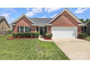 Charming single-story red brick home featuring manicured lawn, tasteful landscaping and a two car garage at 3523 Brickwood Cir, Midland, NC 28107