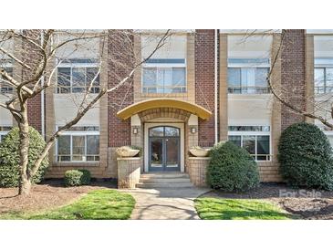 Elegant brick building entrance with an arched doorway and manicured landscaping at 404 N Laurel Ave # 11, Charlotte, NC 28204