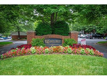 Community entrance sign with brick pillars and colorful flower bed landscaping at 5601 Fairview Rd # 11, Charlotte, NC 28209