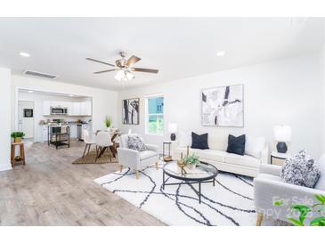 Bright open-concept living room with sleek decor and an adjoining kitchen and dining area at 810 W Raleigh Ave, Statesville, NC 28677