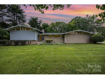 Charming single-story home featuring a lush green lawn and mature landscaping with a mix of brick and siding at 985 Needmore Rd, Woodleaf, NC 27054