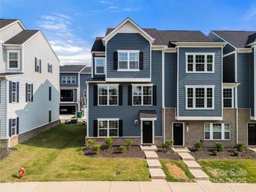 Inviting blue townhome with brick accents and a well-manicured lawn at 120 August Ln, Stallings, NC 28104