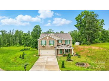 Charming two-story brick home with green shutters and a well-manicured front yard on a sunny day at 124 Vintage Woods Ct, Shelby, NC 28150
