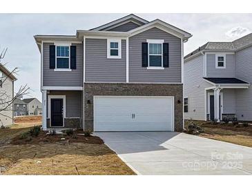 Two-story home with gray siding, brick accents, a two-car garage, and a neatly paved driveway at 213 J.P. Dr, Albemarle, NC 28001