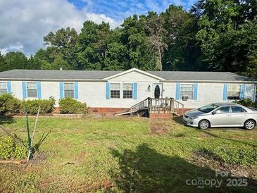 Charming single-story home with light siding, blue shutters, and a well-maintained front yard at 2194 Sterling Ridge Dr, Newton, NC 28658