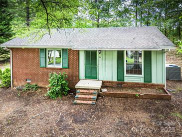Charming single-story home with brick and siding, and green shutters nestled among mature trees at 24 19Th Nw St, Hickory, NC 28601