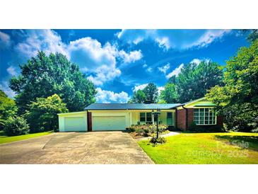 Charming single-story home with an attached garage and a well-maintained lawn and garden in a treed neighborhood at 2405 Forrestbrook Dr, Kannapolis, NC 28083
