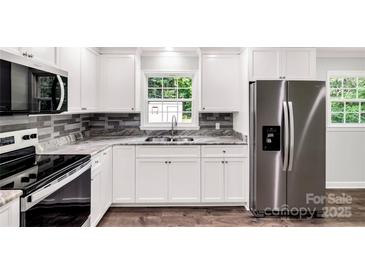 Modern kitchen featuring stainless steel appliances, white cabinetry and beautiful granite countertops at 279 Bailey Rd, Lancaster, SC 29720