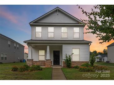 Charming two-story home featuring a covered porch with stone accents and well-manicured landscaping at 422 Nixon Rd, Belmont, NC 28012