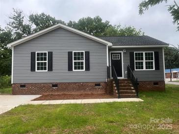 Charming home with gray siding, black shutters, brick foundation and landscaped front yard at 506 Locust St, Rock Hill, SC 29730