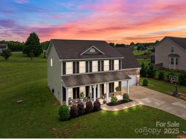 Stunning two-story home with a landscaped front yard and a cozy porch perfect for relaxing evenings at 5668 Stanfield Ridge Dr, Stanfield, NC 28163