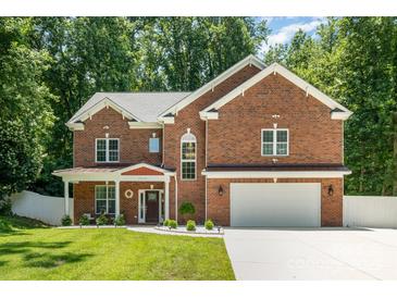 Charming two-story brick home featuring a manicured lawn, a two-car garage, and a welcoming front porch at 8418 Knollwood Cir, Charlotte, NC 28213
