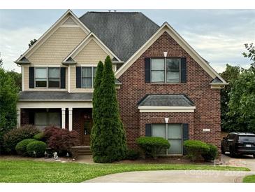 Charming brick two-story home with manicured lawn, black shutters, and mature trees at 8620 Rolling Fields Rd, Charlotte, NC 28227