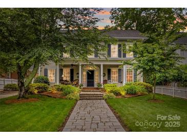 Charming two-story home featuring a welcoming front porch, landscaped yard, and inviting stone pathway at 117 N Mulberry St, Statesville, NC 28677