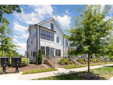 Charming two-story townhome features white siding, black trim, and manicured landscaping at 11938 Fiddlers Roof Ln, Charlotte, NC 28277