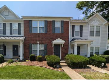 Charming brick townhouse featuring a well-manicured lawn and neatly trimmed shrubbery at 12564 Jessica Pl, Charlotte, NC 28269