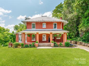 Charming two-story red brick home with a covered porch and manicured lawn at 128 W End St, Chester, SC 29706