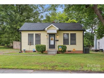 Charming yellow home featuring a welcoming entrance, well-maintained lawn, and mature trees at 1425 3Rd Street Ne Pl, Hickory, NC 28601