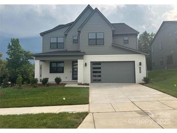 Two-story home with a modern garage, well-manicured lawn, and neutral color scheme at 15005 Brownleigh Ln # 27, Huntersville, NC 28078