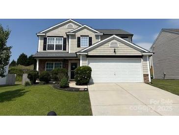 Charming two-story home featuring a manicured lawn and a spacious two-car garage at 1583 Cold Creek Pl, Huntersville, NC 28078