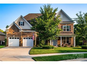 Charming brick home featuring a manicured lawn, two-car garage, and welcoming front porch at 159 Holly Ridge Dr, Mooresville, NC 28115