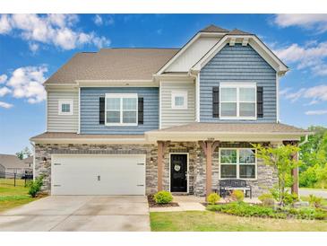 Charming two-story home featuring blue and gray siding, stone accents, and a well-manicured front yard at 16404 Wavenly House Dr, Charlotte, NC 28273