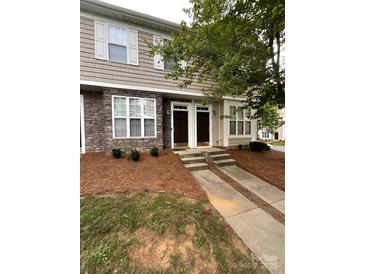 Charming two-story townhouse featuring stone accents and landscaped front yard at 571 Goldstaff Ln, Charlotte, NC 28273